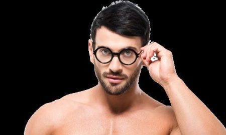 Shirtless man with glasses reading a book