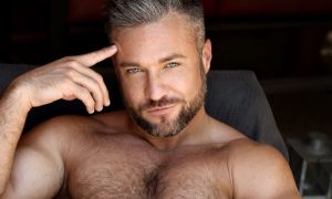 Colby Melvin reclining, resting a finger against his temple