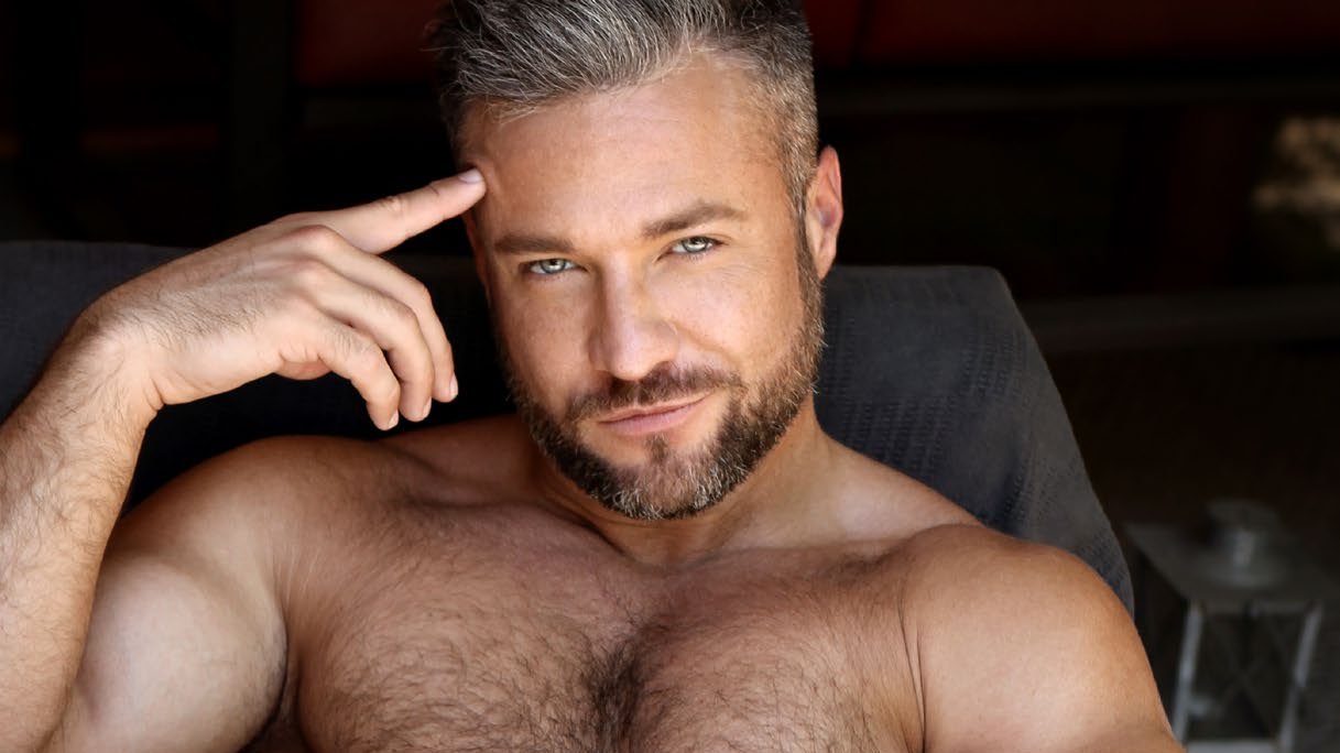 Colby Melvin reclining, resting a finger against his temple
