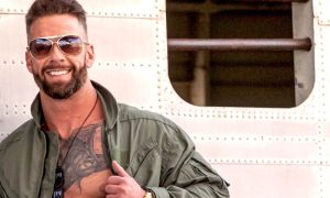 Kyland smiling in open flight suit against aircraft fuselage - DNA #280 Digital Extra