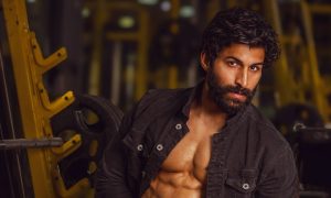 Arvind Baldiya in the gym, wearing an open black jacket and white briefs