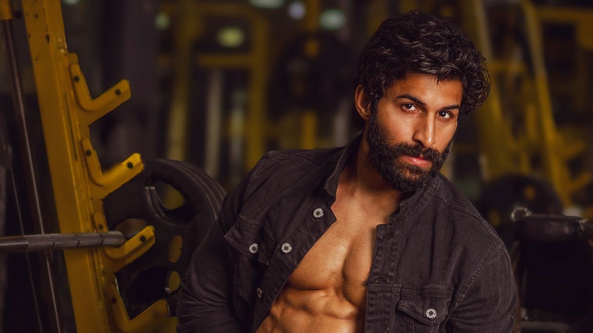 Arvind Baldiya in the gym, wearing an open black jacket and white briefs