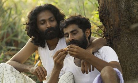 Ji Jo Kuriakose's Velipadu: The Revelation - two men embrace in a forest scene