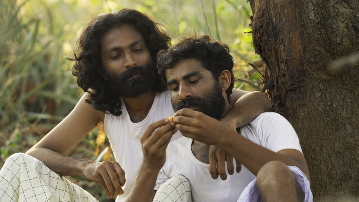 Ji Jo Kuriakose's Velipadu: The Revelation - two men embrace in a forest scene