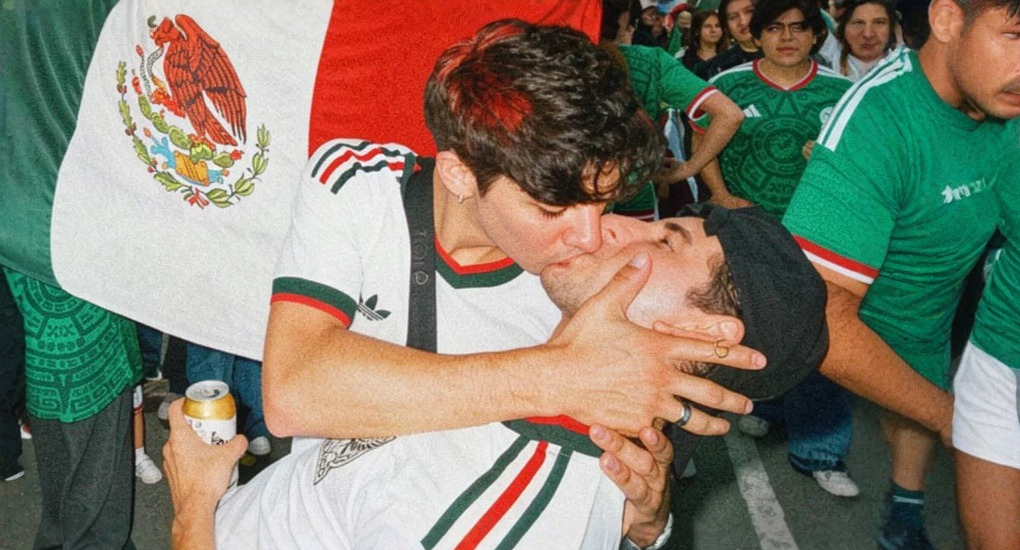 Issac Flores kisses his boyfriend Edson Gonzalez in front of a Mexican flag at a World Cup watch party in Mexico City